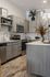 Modern kitchen with sleek gray cabinetry, stainless steel appliances, and elegant decor under pendant lighting.