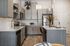 Modern kitchen with sleek grey cabinets, stainless steel appliances, and inviting breakfast bar accented by stylish decor.