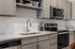 Sleek modern kitchen with stainless steel appliances, elegant cabinetry, and a stylish faucet, perfect for culinary adventures.