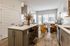 Modern open-concept apartment featuring stylish kitchen with island, bright living area with large windows, and elegant wood flooring.