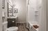 Elegant bathroom with a freestanding bathtub, stylish wooden vanity, and modern decor, featuring light wood flooring and soft ambient lighting.