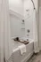 Elegant bathroom featuring a modern bathtub with a chic wooden tray, stylish decor, and sleek chrome fixtures.