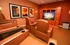 Luxurious home theater room with plush leather recliners, classic movie posters, and a large screen in a cozy setting.