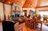 Inviting living room with rustic stone fireplace, warm wood ceiling, and cozy seating, perfect for relaxation and entertainment.