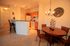 Inviting open-concept dining and kitchen area with warm lighting, modern decor, and sleek wooden accents.
