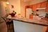 Inviting kitchen with warm wood cabinets, stylish bar seating, and modern appliances, perfect for entertaining.
