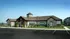 Charming stone-accented building with a welcoming entrance, surrounded by lush landscaping and ample parking space.