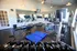 Modern fitness center equipped with treadmills, stationary bikes, free weights, and ample natural light.