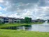 Charming residential apartments with scenic views of a lush landscaped lawn and a serene pond with a fountain.