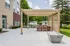 Chic outdoor patio featuring a stylish pergola, modern bar seating, and lush greenery, perfect for entertaining.