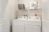 Modern laundry room featuring Whirlpool washer and dryer with elegant shelving for storage.