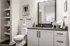 Modern bathroom with sleek vanity, large mirror, and elegant open shelving for towels.