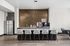 Modern apartment kitchen with sleek countertops, a stainless steel refrigerator, and a stylish coffee bar setup.