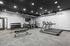 Modern apartment gym with sleek treadmills, versatile exercise machines, and a free weight area under ambient lighting.