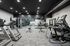 Modern fitness center featuring state-of-the-art gym equipment, including treadmills, benches, and weight machines in a spacious, well-lit environment.