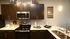 Modern kitchen with sleek cabinets, stainless steel appliances, and elegant decor, creating a cozy gathering place.