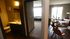 Modern apartment interior showcasing a cozy bathroom, bright hallway leading to a sunlit living area with chic dining setup and large windows.