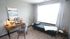 Inviting home office with stylish wooden desk, cozy seating, and bright natural light.
