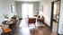 Modern living room with sleek hardwood floors, cozy seating area, and a chic dining nook, providing a bright, inviting atmosphere.