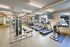 Modern fitness center with state-of-the-art exercise equipment and large windows for natural light.