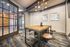 Contemporary meeting room with stylish industrial furniture, framed art, and a chic chandelier, perfect for inspiring collaboration.