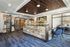 Modern and inviting office lobby with rustic wooden reception desk, stylish blue carpeting, and elegant floral arrangement.