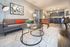 Chic living area with modern furniture, art-inspired decor, and an open kitchen, perfect for stylish urban living.