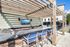 Chic outdoor patio with wooden pergola, featuring a sleek countertop, modern grill, and cozy seating area perfect for entertaining.