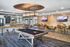 Modern recreation room featuring a stylish pool table, chic seating area, and contemporary decor perfect for socializing.