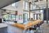 Modern open-concept kitchen with high ceilings, stylish pendant lighting, and a spacious wooden countertop bar seating area.