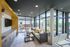 Modern living space with a sleek kitchenette, cozy seating area, and expansive windows illuminating the room with natural light.