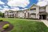 Charming apartment complex with well-maintained landscaping and inviting balconies under a bright blue sky.