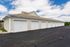 Charming and well-maintained row of individual garages with seamless access, set against a backdrop of clear, blue skies.