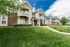 Charming apartment complex with inviting balconies and well-maintained green space under a bright blue sky.
