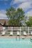 Inviting apartment community pool area with comfortable lounge chairs and lush greenery, perfect for relaxation and leisure.