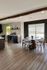 Contemporary open-concept dining area with elegant wooden flooring, stylish round table, and abundant natural light.
