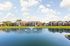 Charming lakeside apartments with spacious lawns, serene views, and elegant architecture under a clear blue sky.
