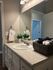Elegant bathroom vanity featuring a modern sink, decorative plants, and plush towels in a welcoming setting.