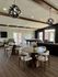 Inviting modern communal space with stylish decor, featuring round dining tables, elegant lighting, and a billiards table for entertainment.