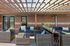 Inviting outdoor patio with stylish wicker seating, vibrant blue cushions, and a charming pergola roof, perfect for relaxing and entertaining.