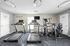 Modern fitness center with state-of-the-art treadmills and exercise bikes, motivational words adorning the wall, bright and inviting space for an energizing workout.