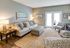 Inviting living room with cozy seating, stylish decor, and natural light from floor-to-ceiling windows.