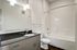Elegant bathroom featuring sleek vanity with a granite countertop, modern fixtures, and a pristine bathtub.