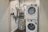 Efficient laundry and utility area with stacked washer and dryer, modern HVAC system, and water heater.