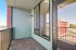 Charming apartment balcony with modern railing, large windows, and stunning city views perfect for relaxation.