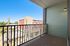 Charming balcony with modern railing, offering a vibrant city view and abundant natural light.