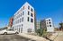 Contemporary apartment building featuring modern design and large windows, with a clean, well-maintained exterior and a bright, clear sky.
