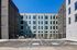 Modern apartment building with sleek architectural design, ample natural light, and secure gated entrance.