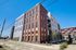 Modern apartment building showcasing a contemporary blend of brick and sleek panel design, perfect for urban living.