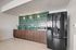 Chic kitchen with modern black appliances, elegant wood cabinetry, and striking green tile backsplash.